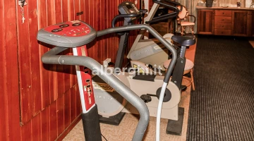Fitnessraum ausgestattet mit Funktionsgeräten, Heimtrainern, Gewichten