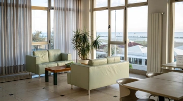 Zona living comune con divani e tavoli