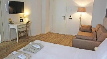Junior suite con divano e tv a schermo piatto