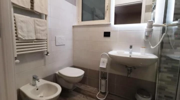 Salle de bain avec douche et sèche-cheveux mural