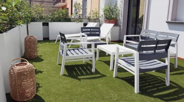 Terrasse mit Tischen und Stühlen ausgestattet