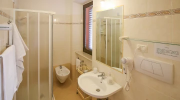 Private bathroom with shower box and wall-mounted hairdryer