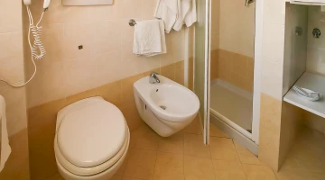 Private bathroom with shower box and wall-mounted hairdryer