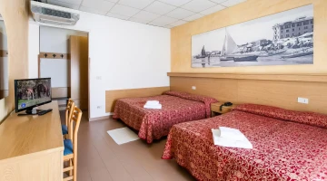 Vierbettzimmer mit TV und Schreibtisch