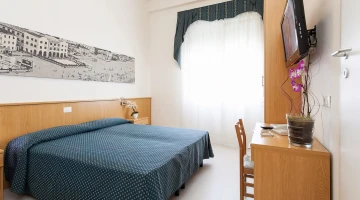 Zimmer mit Doppelbett und Schreibtisch