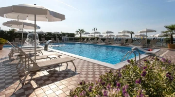 Piscine avec parasols et transats