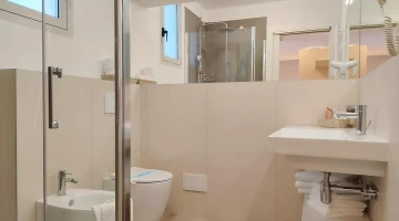 Eigenes Badezimmer mit Duschkabine und wandmontiertem Haartrockner