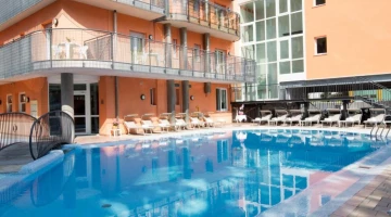 Swimming pool with sun loungers at the edge of the pool