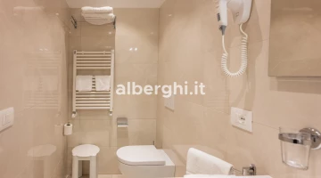 Salle de bain avec sèche-cheveux et serviettes