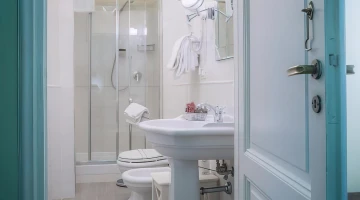 Salle de bain avec douche et sèche-cheveux