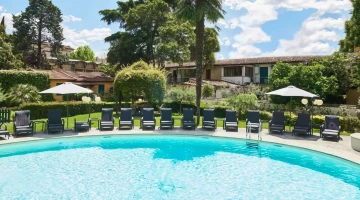 Swimmingpool mit Liegestühlen und Sonnenschirmen