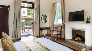 Zimmer mit Kamin, Fernseher und privatem Balkon