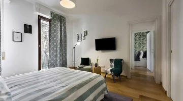 Chambre verte avec balcon, sièges et télévision