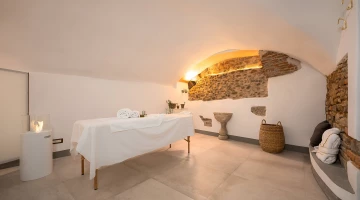 Massage room with bed and bathrobes