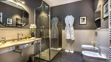 Bagno con box doccia, accappatoi e ciabattine