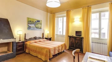 Room with double bed and fireplace