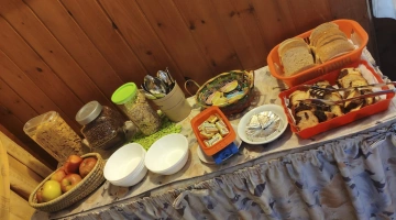 Frühstücksbuffet mit Brot, Kuchen, Obst und Müsli