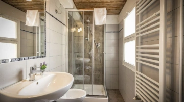 Badezimmer mit Dusche und Handtüchern