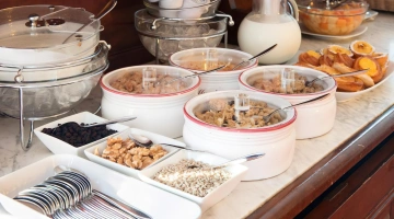 Buffet della colazione con cereali, yogurt, latte e frutta