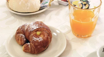 Frühstück mit Brot, Butter, Brioche und Saft