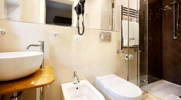 Badezimmer mit Haartrockner und Duschkabine