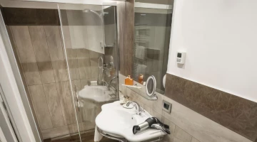 Salle de bain privée avec douche, sèche-cheveux et set de courtoisie
