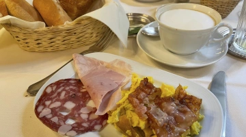 Savory breakfast with cold cuts, salami, bacon and eggs