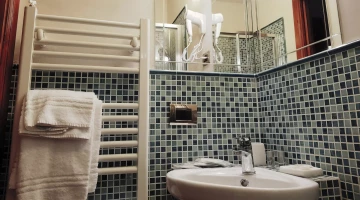 Salle de bain avec serviettes et sèche-cheveux