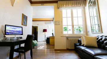 Gemeinsames Wohnzimmer mit Sofa und Schreibtisch mit Computer