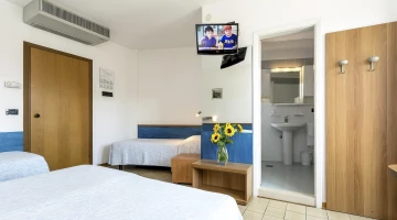 Einfaches Dreibettzimmer mit eigenem Bad und TV