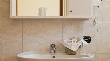 Salle de bain avec sèche-cheveux et set de serviettes