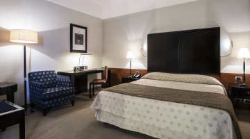 Room with double bed and desk corner