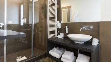 Salle de bain avec cabine de douche, meuble vasque et sèche-cheveux