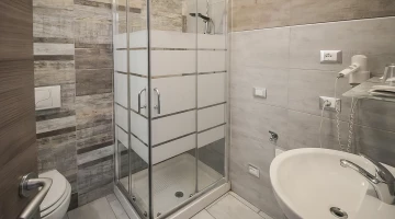 Salle de bain avec cabine de douche et sèche-cheveux
