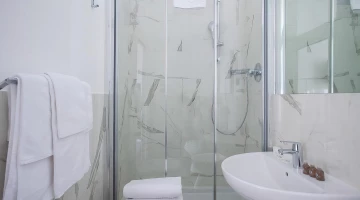 Bathroom covered in white marble with shower box