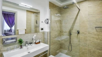 Großes Badezimmer mit Dusche, Vergrößerungsspiegel und Pflegeprodukten