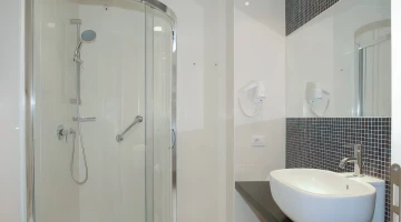 Private bathroom with wall-mounted hairdryer