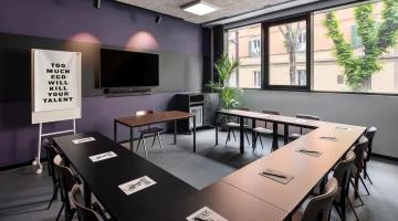Sala meeting con schermo video e lavagna a fogli mobili