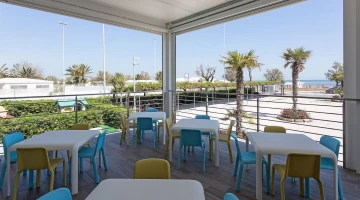 Veranda mit Tischen und Stühlen ausgestattet