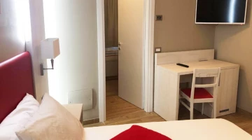 Dreibettzimmer Greta mit TV und Schreibtisch
