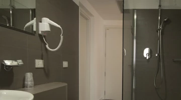 Bathroom with shower cubicle and wall-mounted hairdryer