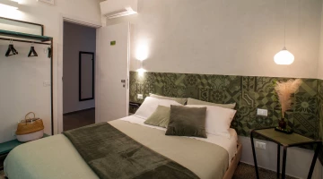 Grünes Doppelzimmer mit offenem Kleiderschrank