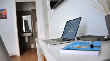 Zimmer mit einem Schreibtisch und einem eigenen Badezimmer