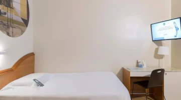 Einzelzimmer mit TV und Schreibtisch