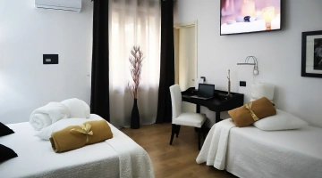 Dreibettzimmer mit Fernseher und Schreibtisch