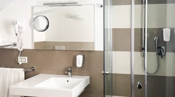 Salle de bain privée avec douche et sèche-cheveux mural