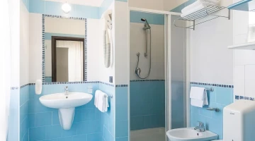 Salle de bain privative avec cabine de douche et sèche-cheveux mural