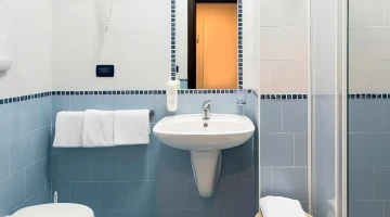 Salle de bain privative avec cabine de douche et sèche-cheveux mural