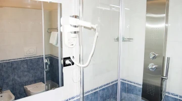 Private bathroom with shower cubicle and wall-mounted hairdryer