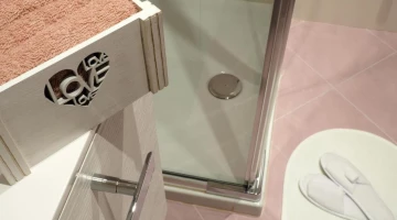 Privates Badezimmer mit Dusche und Hausschuhen